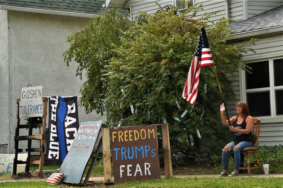 Lori Arnold's display in her yard in September. It’s festooned with colorful hand-painted signs that say “Support ICE” and “BLM: Burn Loot Murder.” (Justin Hicks/IPB News)