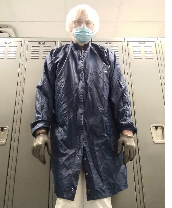 Janitorial contractor Dennis Osborn in his gear he wears to work to keep himself safe. He wears a hair net, gloves, a long snap-button gown, goggles over his glasses, and a disposable mask. Image provided by Dennis Osborn.