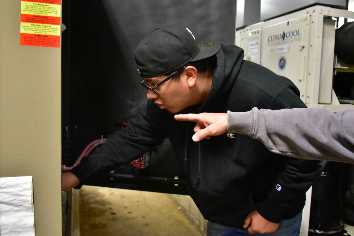 Ramiro Delgado takes directions from Keith Fondaw, a steamfitter with Indianapolis Public Schools, while he learns on the job. Delgado is a high school student and participant in the Modern Apprenticeship Program in Indianapolis. Image credit: Justin Hicks, IPB News
